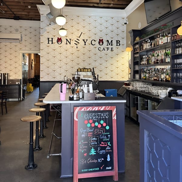 Interior of Honeycomb Cafe with a bar, stools, and a Christmas specials chalkboard.